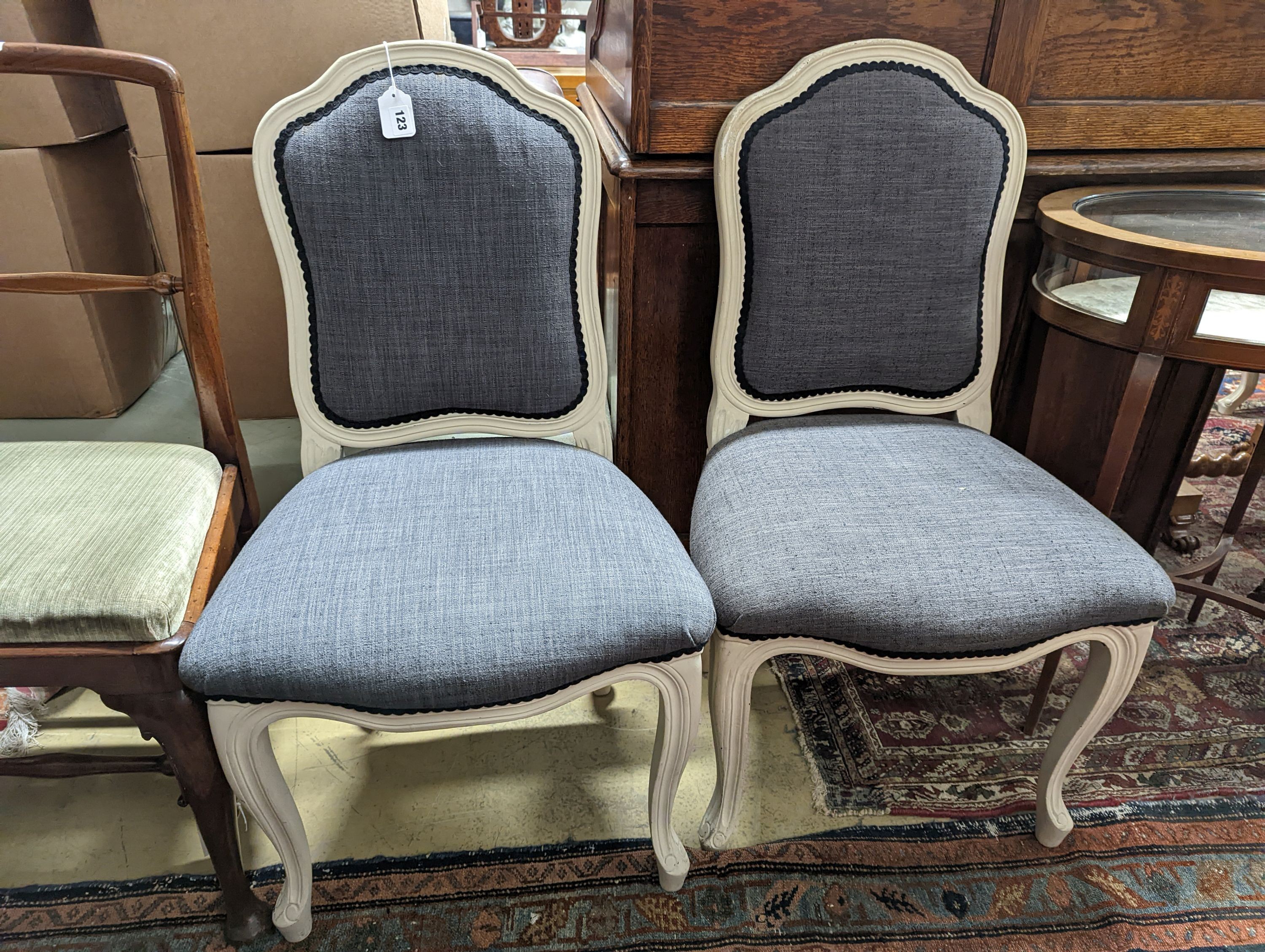 A pair of grey upholstered dining chairs